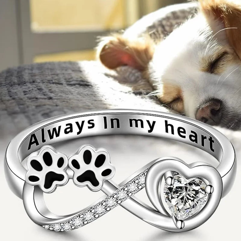 Ring with paw-shaped zirconia, heart, and infinity symbol.